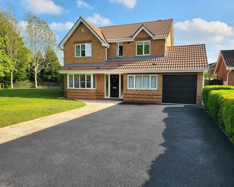 The same driveway restored to a deep jet-black finish