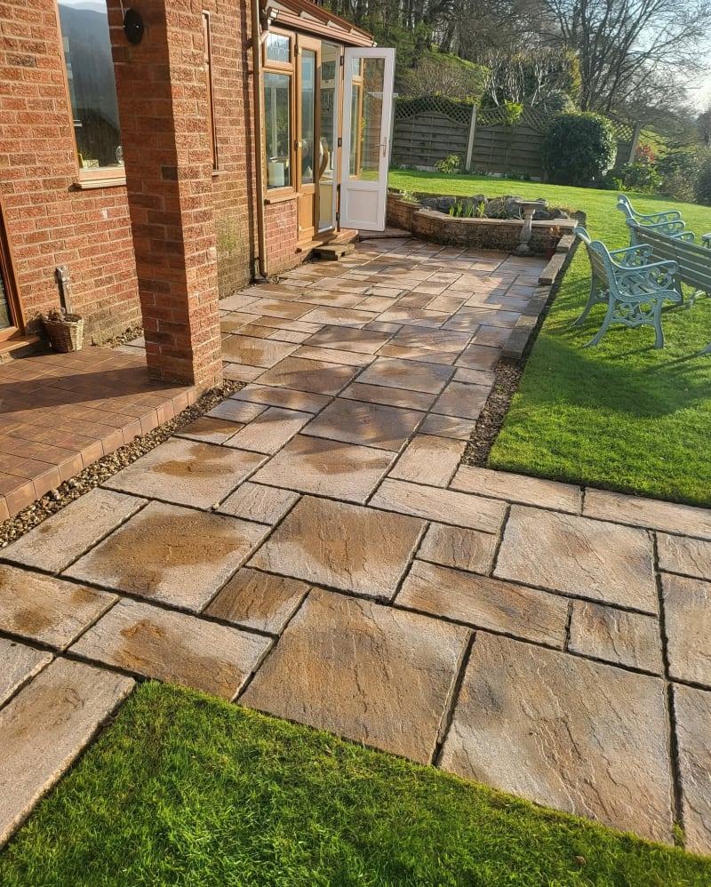 Half-cleaned block paving driveway showing the difference pressure washing makes